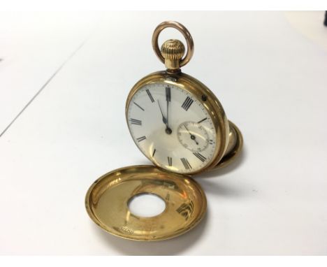 A gold half hunter button wind pocket watch, a 9ct gold top ring, 18ct outer case. Inner back plate made from base metal.