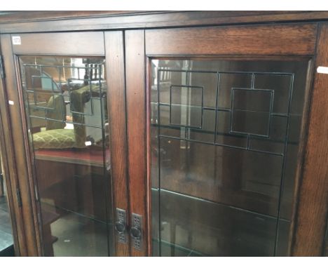 A Modern Quality Oak Display cabinet with lead light pannels in the style of The Glasgow school Arts and Crafts. With three g