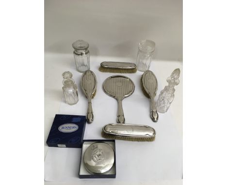 A five piece silver brush set, some silver topped glass bottles and a trinket box