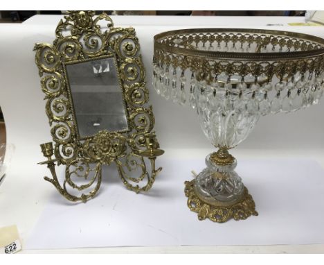 A brass wall sconces and mirror combination combined with a glass and brass lamp decorated with smaller teardrop shaped glass