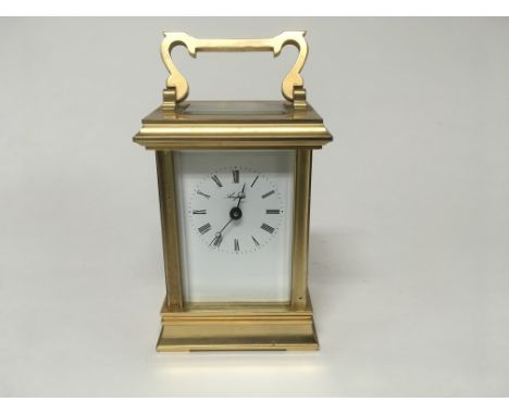 A brass cased carriage clock the enamel dial with Roman numerals