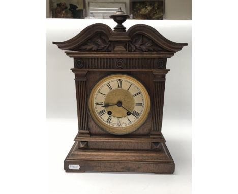 An Edwardian clock with Roman numerals together with two wooden framed mirrors.