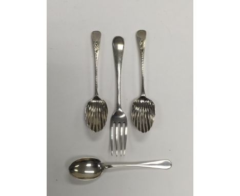 A collection of four examples of silver cutlery comprising three teaspoons and a fork.