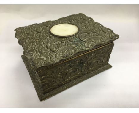 A brass trinket box with scrollwork decoration.