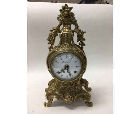 A brass cased French style clock with key.