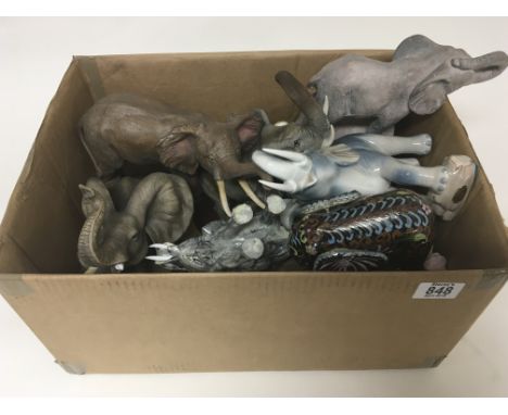 A box containing a collection of ceramic and other elephant figures.