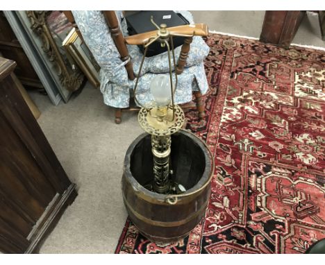 A brass bound barrel containing a chimney sweep and a small lamp.