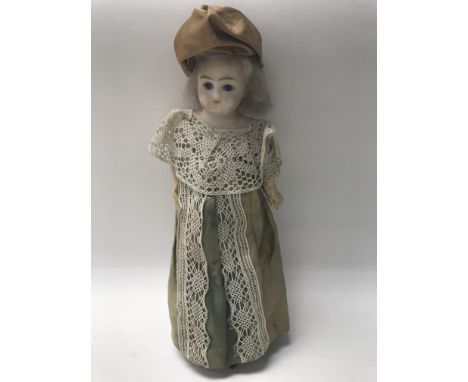 An Edwardian possibly late Victorian composition doll with wax head and ceramic arms and legs. Height approx 34cm