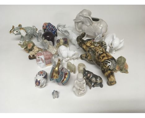 A collection of ceramic and porcelain elephants and other elephant figures.