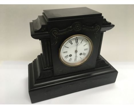 An 8 day black slate mantle clock with floral swag decoration.