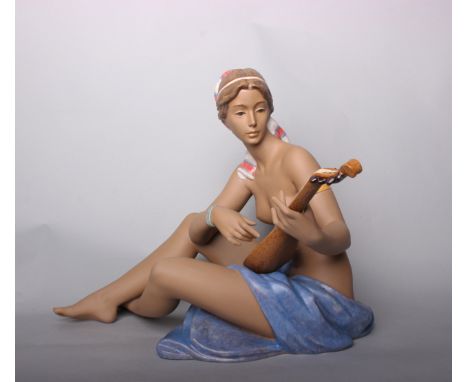 Lladro - a seated figure of a topless lady playing a lute, No.997, signed to base 'Alfredo Llorens, C. Bauset', 36cm high.