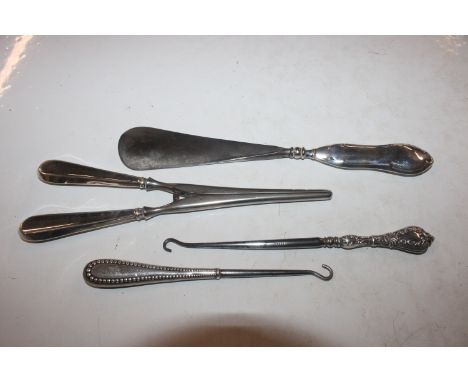 A pair of silver handled glove stretchers; a silver handled shoe horn and two silver handled crochet hooks