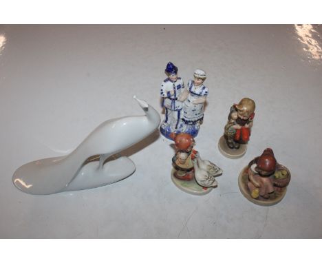 Three Hummel figures of children; a white glazed porcelain study of a peacock and a late Victorian hollow figure group