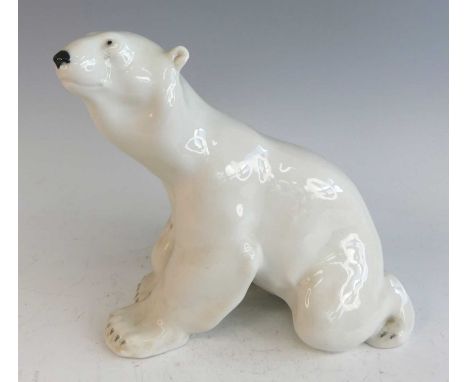 A mid-20th century Russian glazed ceramic model of a polar bear, in seated pose, printed factory mark verso, h.26cm, length 2