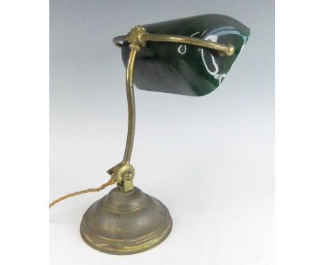An early 20th century American lacquered and weighted brass banker's desk lamp, having a green glass domed shade, with adjust