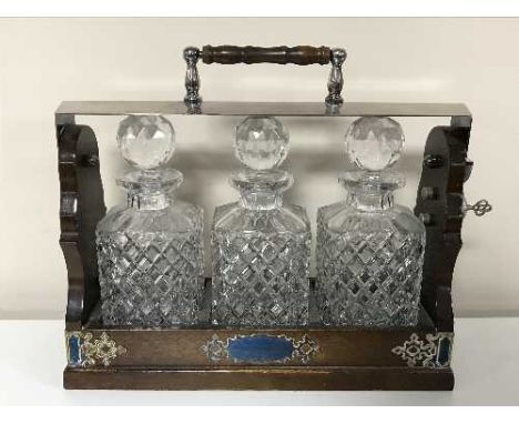 A Victorian style three decanter Tantalus with silver plated mounts 