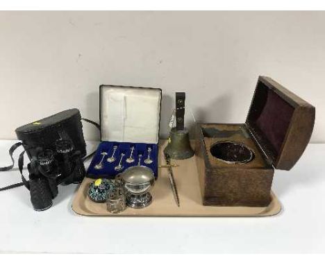 A tray of brass hand bell, glass paperweight, plated napkin rings, cased silver jubilee tea spoons, domed tea caddy and a pai