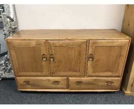 An Ercol elm triple door low sideboard