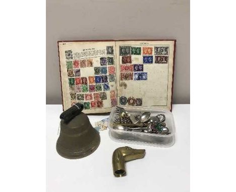 A brass hand bell together with a Victory stamp album and a tub containing carved brass walking stick head, letter opener etc