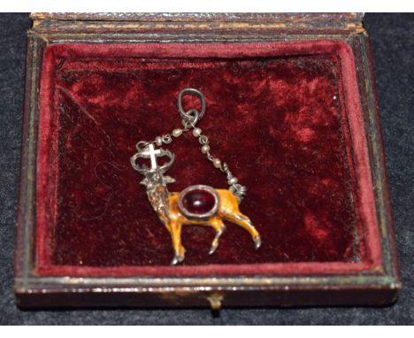 A 19th century silver and enamel St Hubertus pendant, the stag set with red garnet, the back engraved with scrolling foliage,