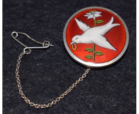A silver and enamel brooch, bird of peace on a red ground, hallmarked James Fenton, Birmingham 1931