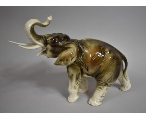 A Royal Dux Elephant with Trunk in Salute, 34cms Long