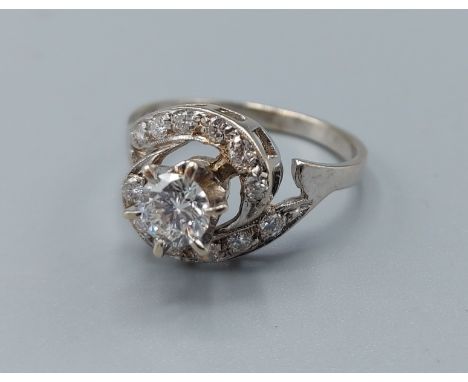 A diamond cluster ring, the central diamond approx. 0.50ct surrounded by smaller diamonds, ring size O, 3.3gms 