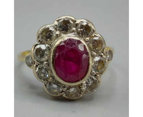 An 18ct gold ruby and diamond cluster ring, set with a central ruby surrounded by diamonds and with diamond shoulders, ring s