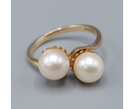 A 9ct yellow gold pearl ring set with two pearls in a crossover setting, ring size O, 3.1gms 