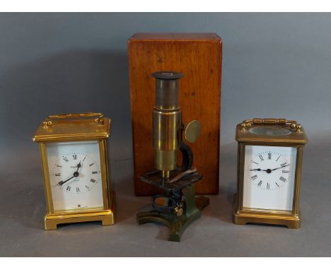 A brass cased carriage clock with lever escapement together with another similar and a small brass microscope in mahogany cas