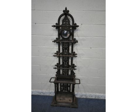 A VICTORIAN CAST IRON HALL STAND, with an arrangement of rails and pegs, a small circular mirror, repeating geometric designs