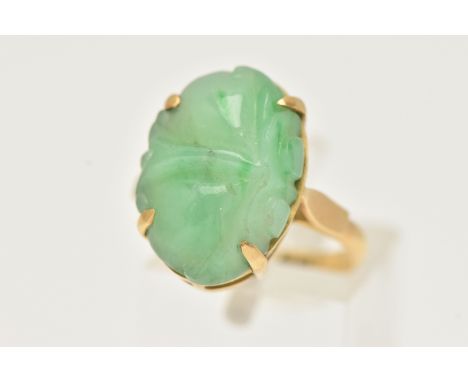 A CARVED JADE RING, oval carved green jade, prong set in yellow metal, approximate length 18mm, yellow metal shank, stamped 1