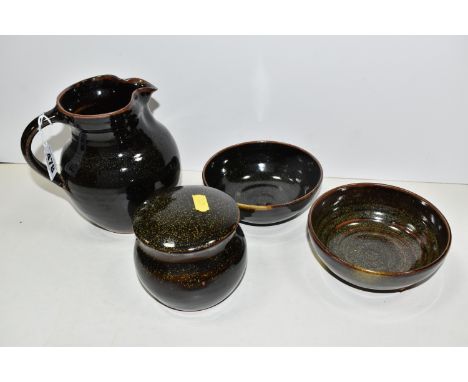 FOUR PIECES OF WINCHCOMBE POTTERY, comprising a jug, height 15.5cm, two bowls and a covered sugar bowl, with speckled tenmoku