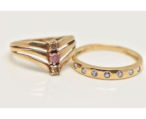 TWO 9CT GOLD GEM SET RINGS, a yellow gold three stone wish bone ring, and a yellow gold seven stone flush set band ring, both