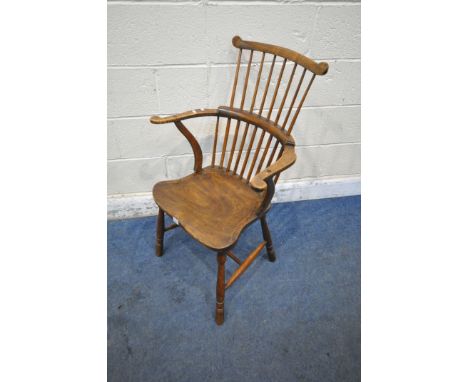 AN EARLY 20TH CENTURY ELM AND BEECH COMB BACK CHAIR, with shaped backrest, swept armrests, dished seat, raised on turned legs