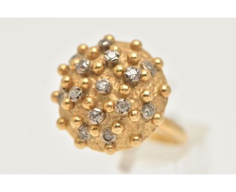 A YELLOW METAL AND DIAMOND BOMBE RING, designed as a raised circular hollow dome with beading detail and fourteen mixed cut d