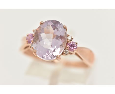 A 9CT GOLD GEM SET RING, an oval cut pink stone, flanked with four round brilliant cut diamonds and two pink sapphires, prong