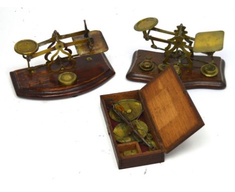 Two sets of brass letter weights and an oak-cased set of scales for silver and gold (3). 