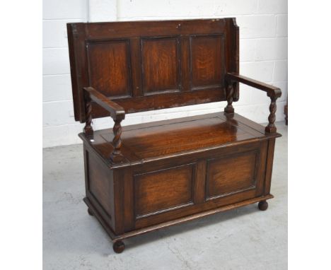 An early 20th century oak monks' bench with hinged seat, width 102cm.