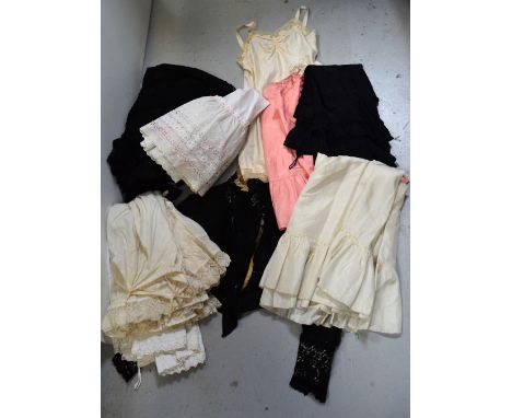 A quantity of Edwardian petticoats and later slips, an early Edwardian black lace net and ribbonwork skirt and an early Edwar