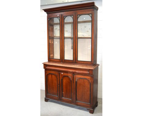 A Victorian bookcase, top section with two glazed doors and central glazed panel, above a long frieze drawer over two cupboar