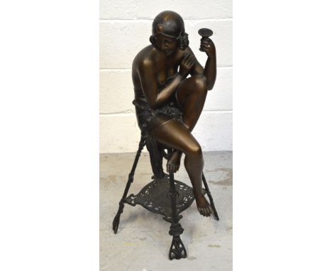 An Art Deco style figure of a seated lady on a table holding a Champagne glass, height approx 82cm.