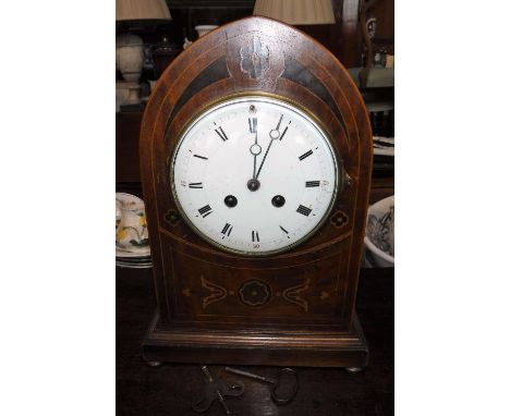 A VICTORIAN INLAID MAHOGANY MANTEL CLOCK, the arched case with an enamel dial on gilt brass bun feet, 12.5" high