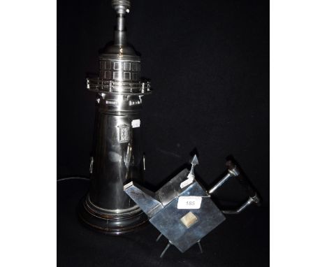 A REPRODUCTION SILVER PLATED TEAPOT and a similar reproduction table lamp in the form of a lighthouse (2)