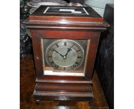 AN EARLY 20TH CENTURY MANTEL CLOCK in a mahogany case with bevelled glass panels and steel dial, 10.5" high
