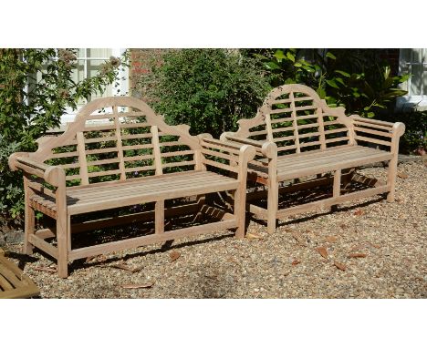 A pair of teak garden benches, of recent manufacture, in the manner of designs by Lutyens, the arched and serpentine backrest