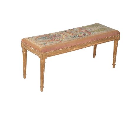 A French giltwood and tapestry upholstered long stool in Louis XVI style, late 19th century, the top with antique tapestry fr