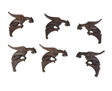 A set of six carved and stained oak wall brackets in Gothic Revival taste, circa 1900, each with a winged gargoyle seated ato