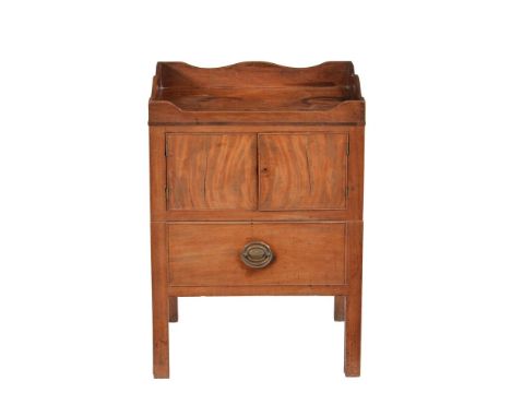 A George III mahogany bedside night commode, circa 1780, the tray top above a pair of cupboard doors and a commode drawer, 87
