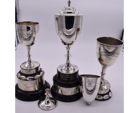 Three silver trophy cups, including a covered example; together with another (a.f), all having stands, 759g weighable. 